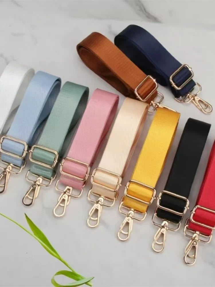 A collection of colorful adjustable nylon shoulder straps in various shades including blue, green, pink, beige, yellow, and b