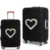 A black rolling suitcase with a heart design featuring the text Pure Love on the cover.