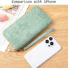 Cartera de cuero PU verde claro con estampado floral junto a un smartphone blanco.
