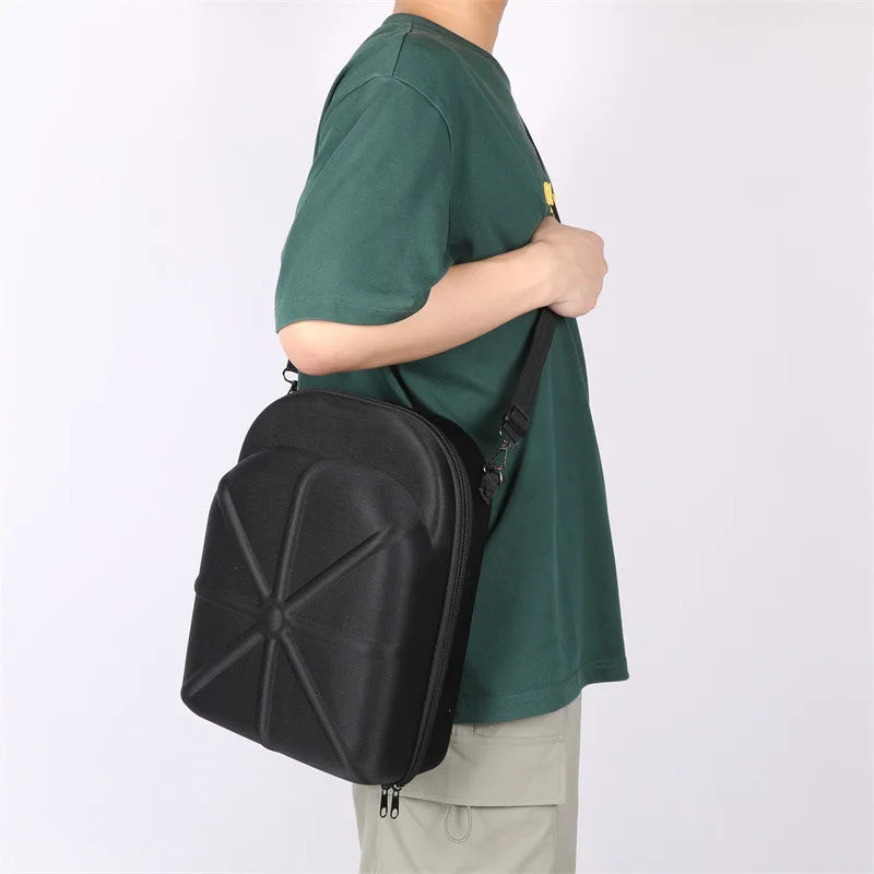 A person wearing a green t-shirt is carrying a black storage bag on their shoulder.