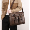 A man wearing a beige utility jacket and black pants carrying a brown PU leather business briefcase bag.