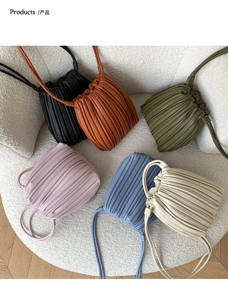 A collection of five pleated PU leather crossbody bags in shades of black, terracotta, olive green, lavender, and blue.