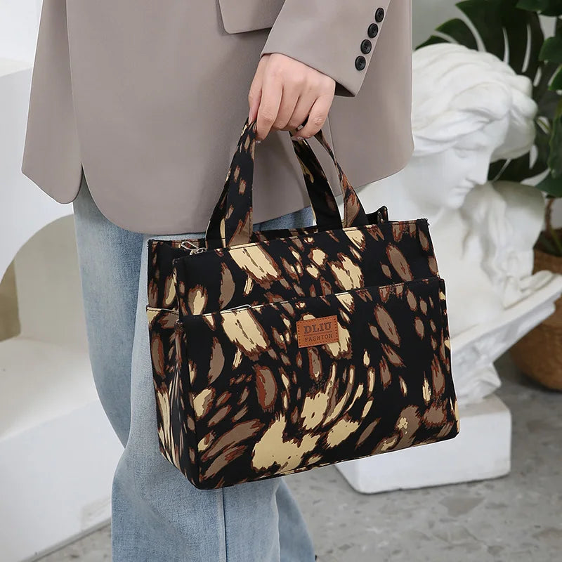 A woman holds a large capacity cloth tote bag with a brown and black leopard print pattern.