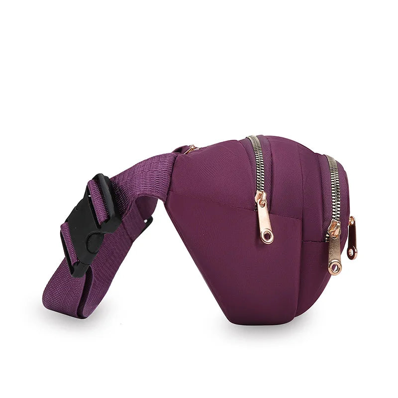 A purple nylon crossbody belt bag with a zipper closure and black strap.