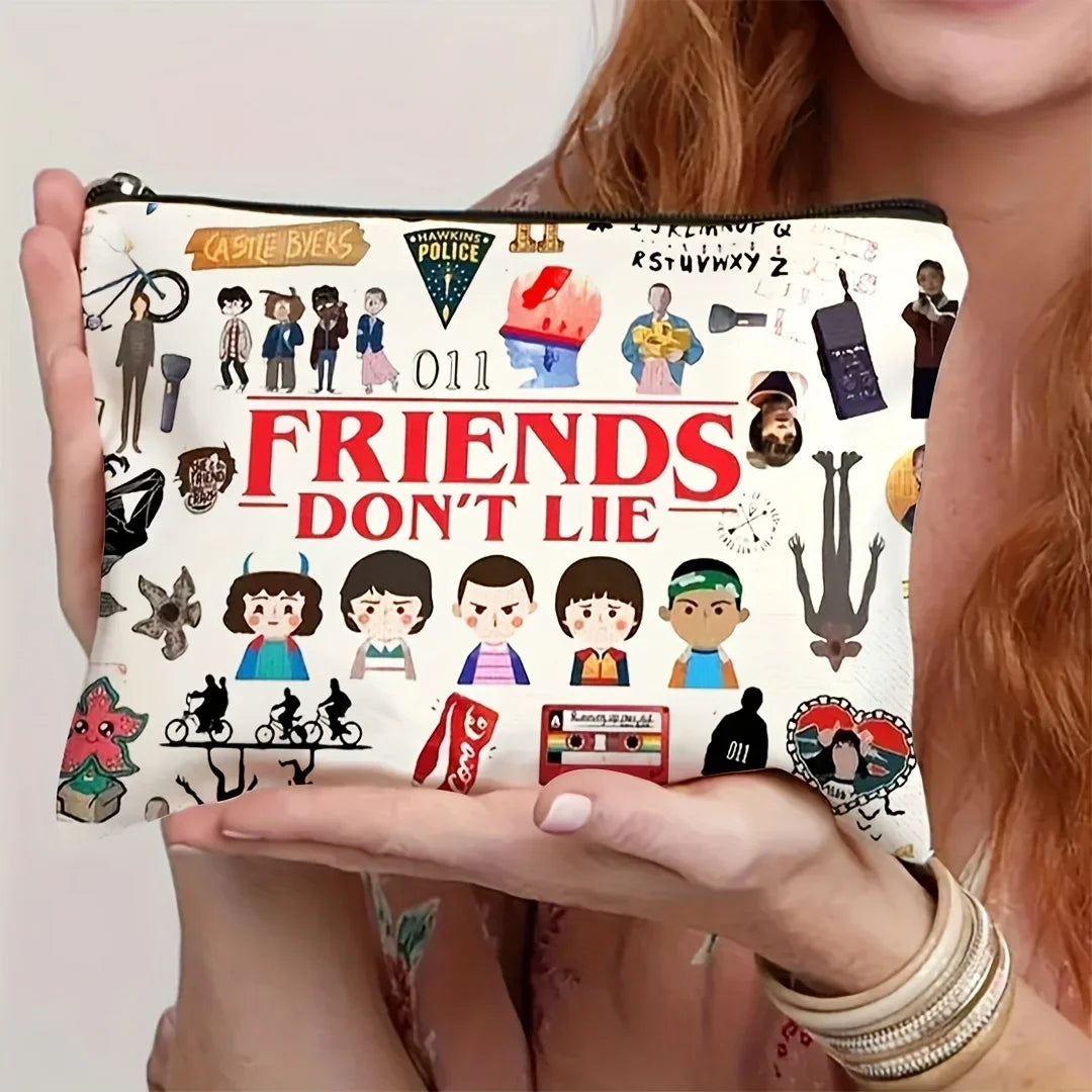 A beige zippered makeup bag featuring a Friends Don't Lie theme with various character illustrations.