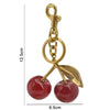 Gold-colored crystal apple charm keychain with a loop and leaf detail