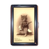 A vintage metal card holder displaying an illustration of a cat playing a guitar.