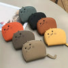 A collection of multi-card wallets shaped like cartoon cats in various colors including orange, black, olive green, and yello