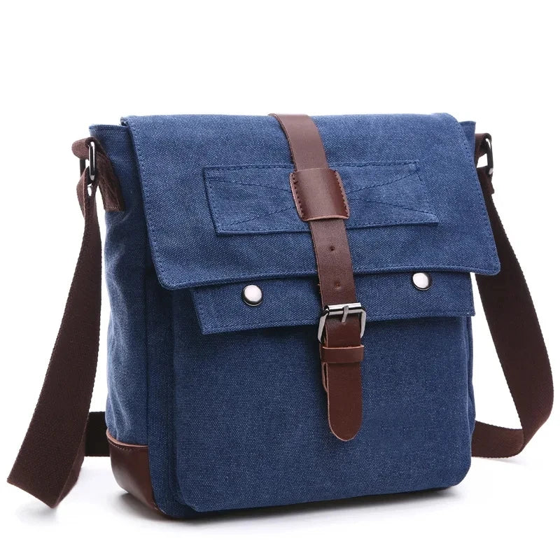 A dark blue canvas messenger bag for men with brown leather straps and buckles.