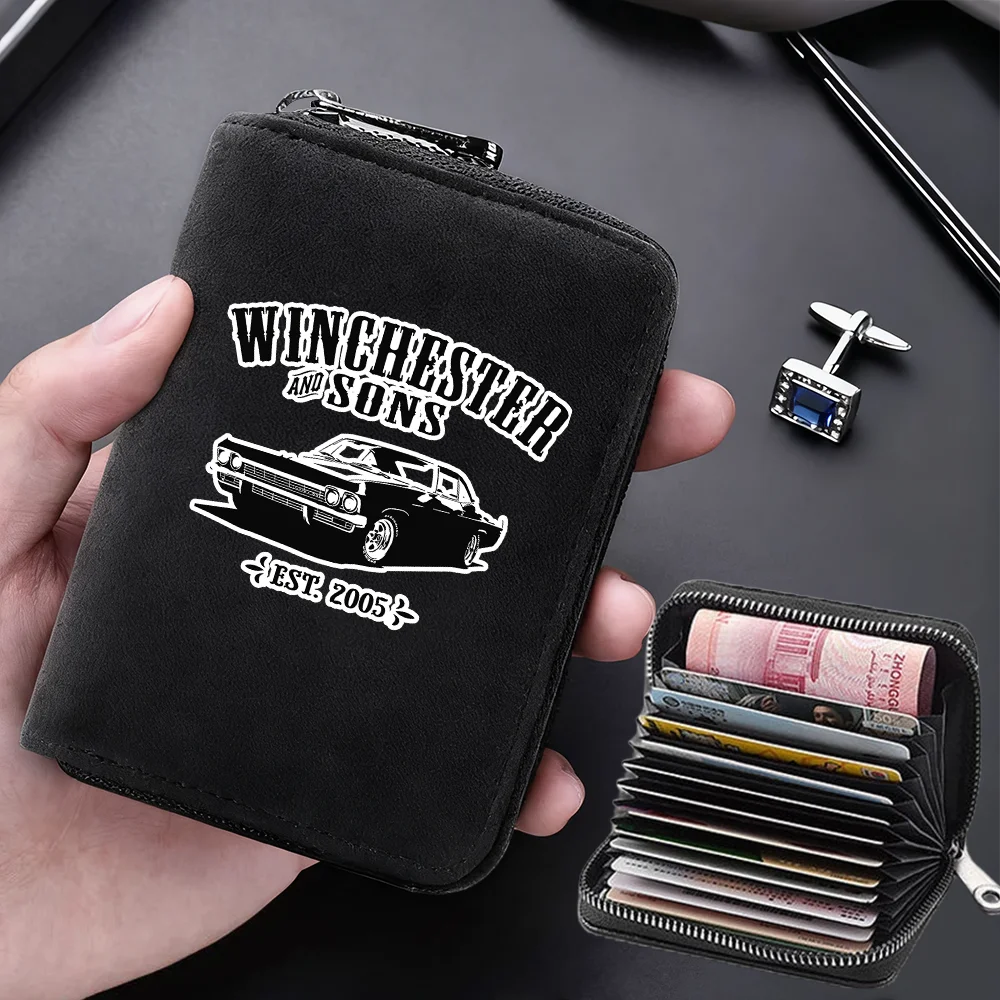 A black leather card wallet with a zipper closure is shown being held, featuring embroidered text and multiple card slots.