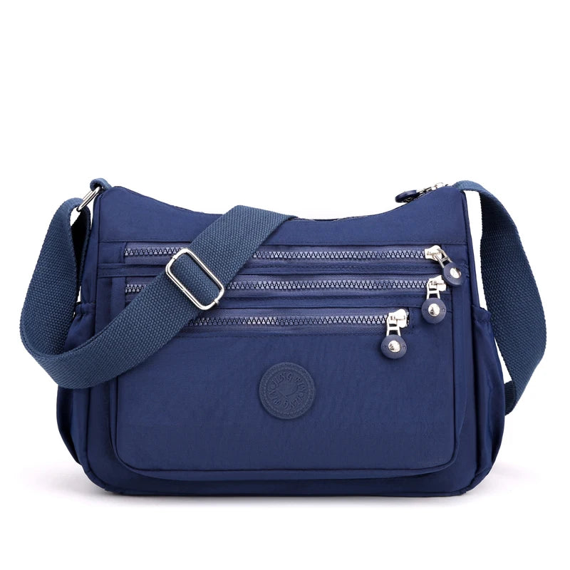 Navy waterproof nylon crossbody shoulder bag with zippered compartments and adjustable strap