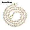 A strand of small, round white pearls on a gold-toned strap.