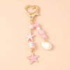 Gold heart-shaped keychain featuring a starfish and various pink and white pearl accents