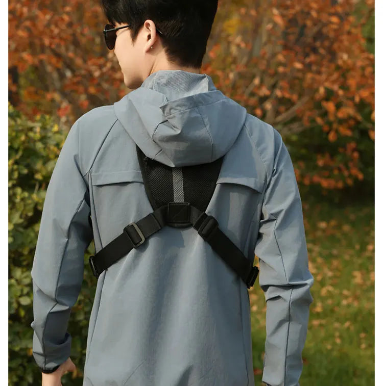 A person wearing a light blue tactical chest rig vest bag for outdoor gear in an outdoor setting.