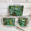 Three versions of an elegant vintage cosmetic pouch in green fabric are displayed, showing different sizes.