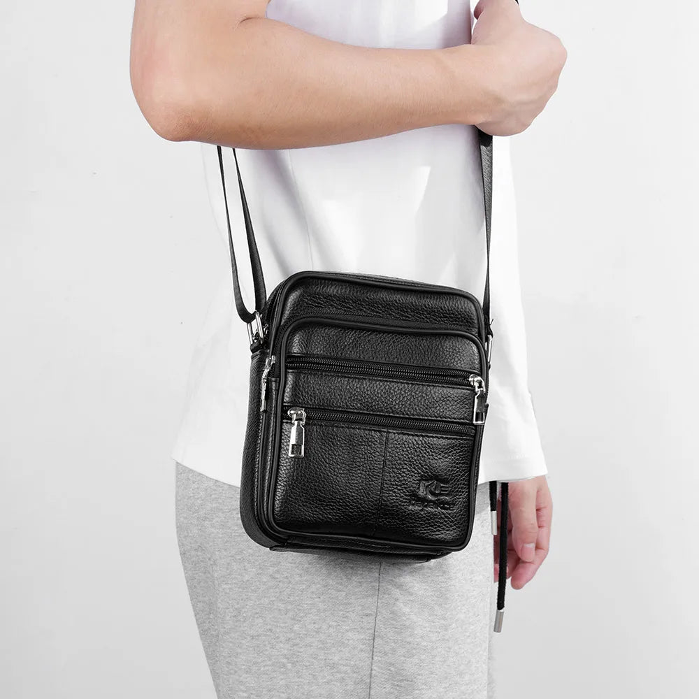 Black men's vintage leather messenger bag worn by a person.