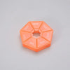 An orange 7-day weekly pill organizer with compartments labeled for the days of the week.