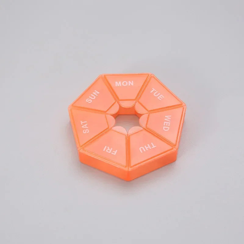 An orange 7-day weekly pill organizer with compartments labeled for the days of the week.