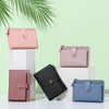 A display of multi-color PU leather mini card holder wallets in pink, black, and blue against a light green background.
