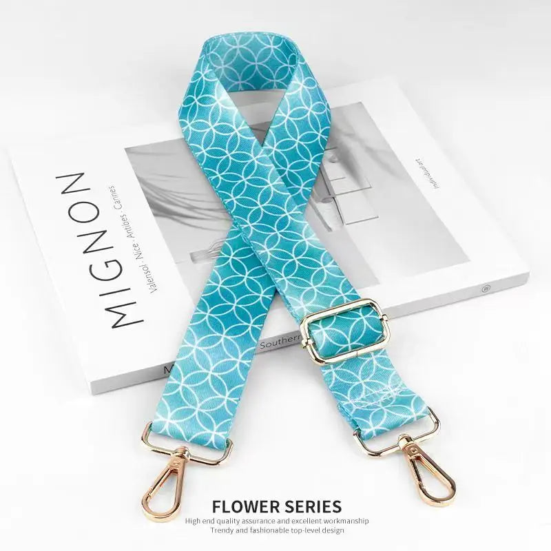 A teal patterned nylon bag strap is displayed on a white box.