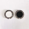 A pair of metal desk hooks with circular openings, one containing white material and the other black material.