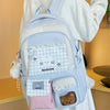 A light blue backpack with white accents and a pink pocket is worn by a person.