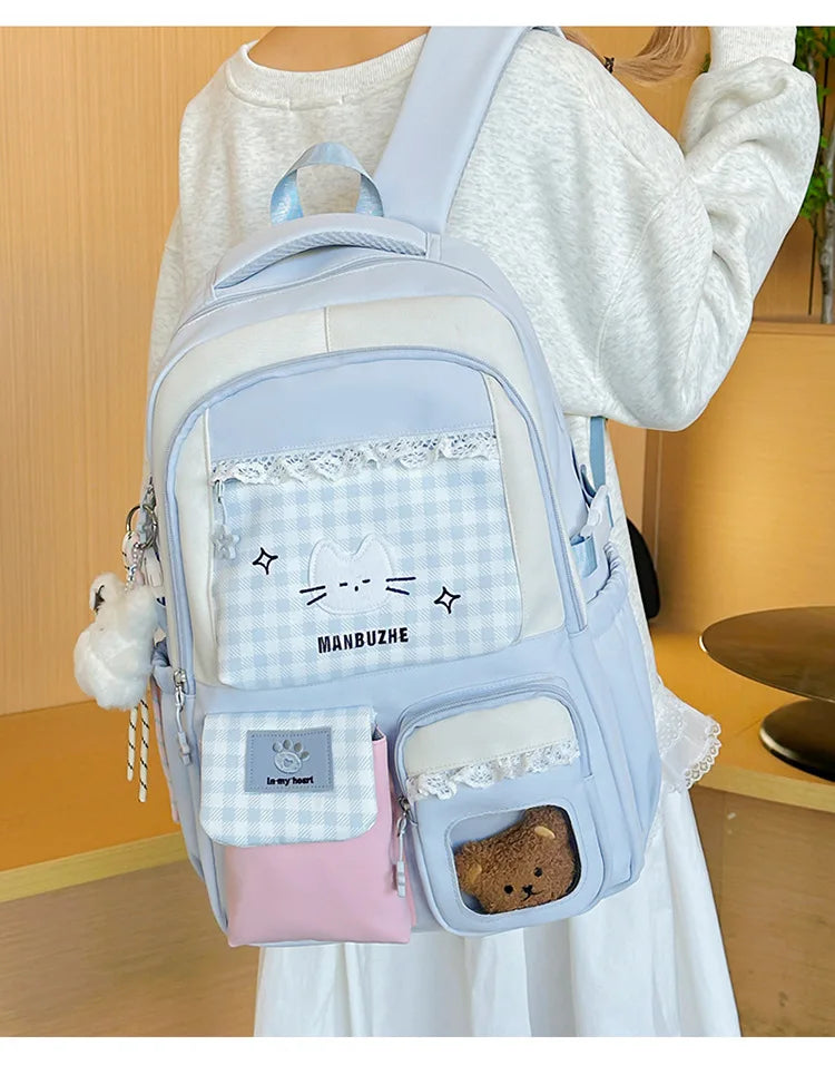 A light blue backpack with white accents and a pink pocket is worn by a person.