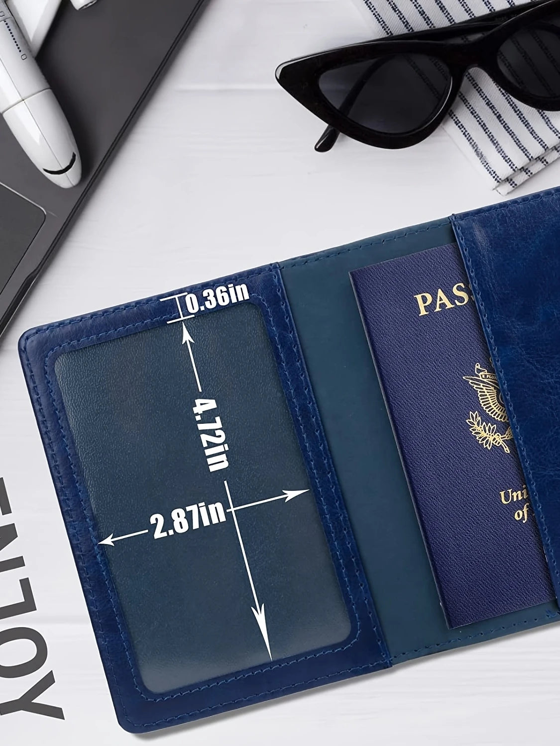 A dark blue leather passport holder wallet with a navy blue interior and gold embossed text is shown on a white surface.