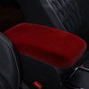 A deep red plush car armrest cushion set is shown inside a black car interior.