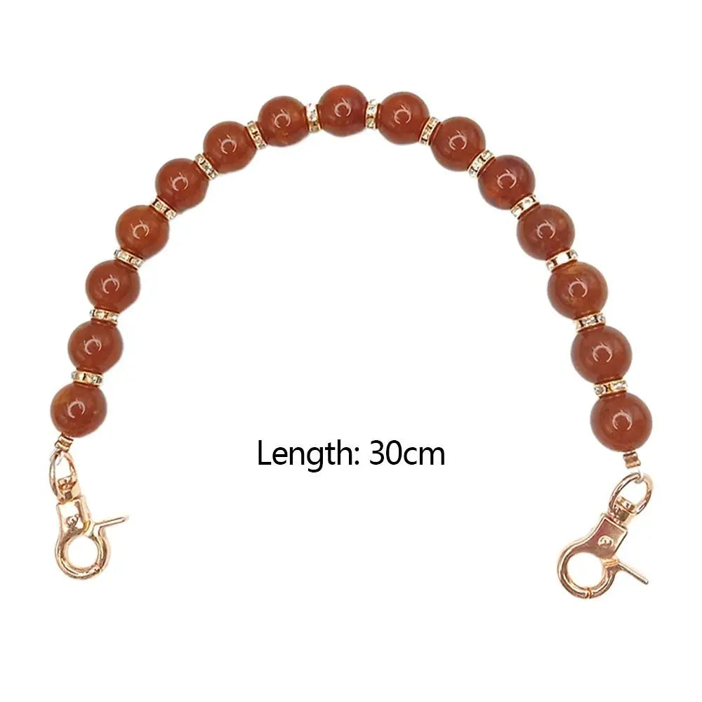 Handcrafted resin stone bead bag chain with round amber beads and gold clasps, measuring 30cm long.