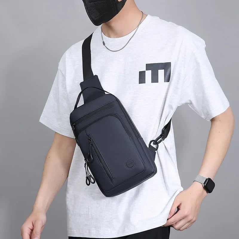 A person wearing a white t-shirt holds a black lightweight chest bag with a phone pocket.