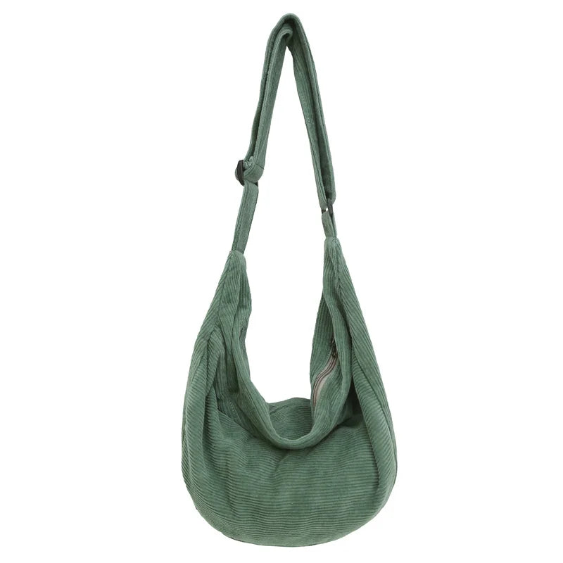 A green corduroy casual crossbody shoulder bag hanging vertically.