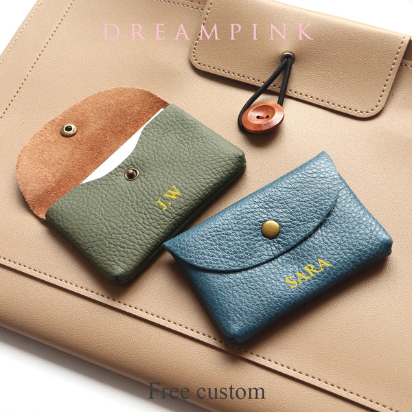 A collection of personalized genuine leather card holders and coin purses in various shades of tan, olive green, and blue-gre