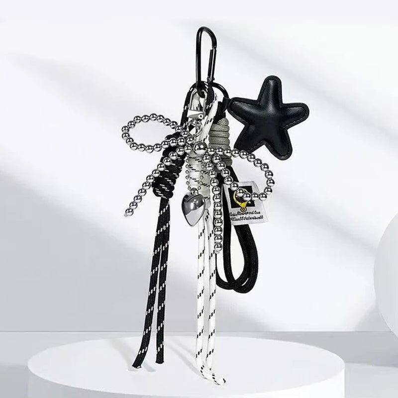 A collection of black and silver beaded keychains featuring a star charm and various charms for bags and backpacks.