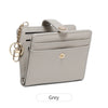 A light grey minimalist wallet with a leather strap and gold chain detail.