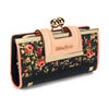 Cartera de mujer con estampado floral rojo y amarillo sobre fondo negro y cubierta de cuero rosa.
