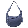 A slate blue canvas crossbody bag with a long strap shown against a white background.
