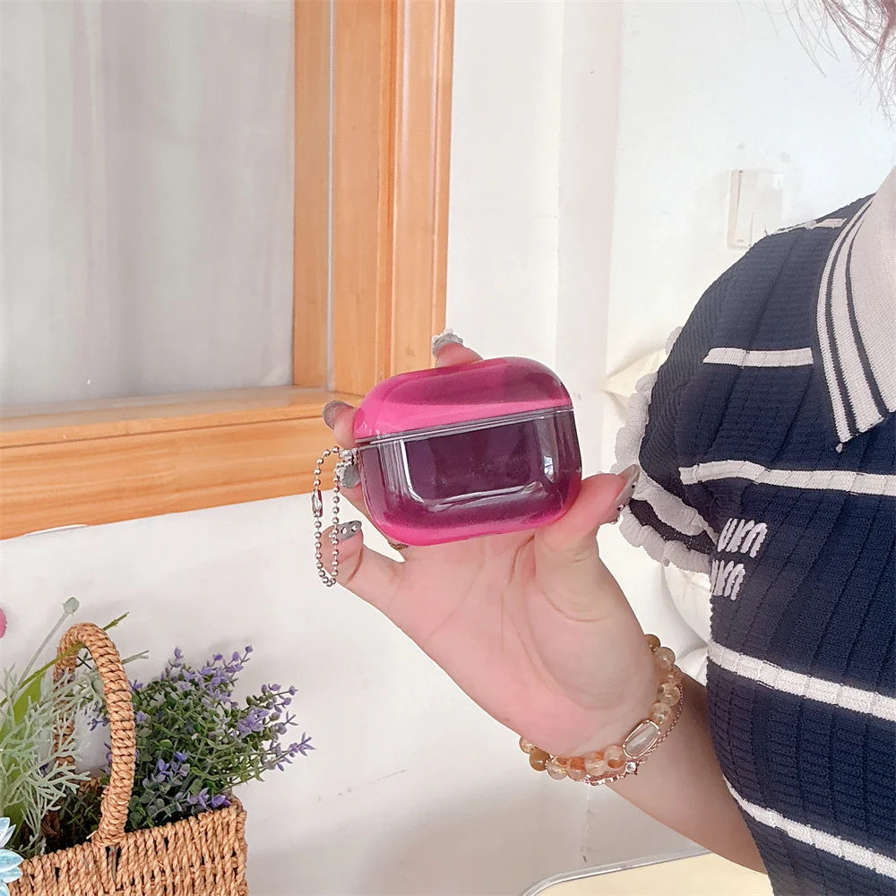 A hand holds a pink luminous sand effect earphone case for AirPods against a white background.