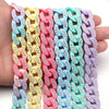 A hand holds a colorful acrylic link chain featuring various pastel colors like pink, yellow, blue, and purple.