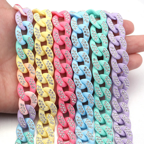 A hand holds a colorful acrylic link chain featuring various pastel colors like pink, yellow, blue, and purple.