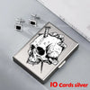 Silver card holder featuring a detailed skull design and small diamond stud earrings.
