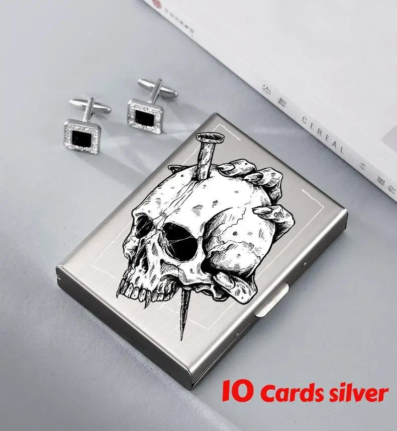 Silver card holder featuring a detailed skull design and small diamond stud earrings.