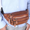 Un sac à la taille en cuir véritable marron pour homme porté sous une chemise bleu clair.