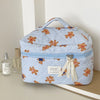 A light blue striped cosmetic makeup bag featuring bear designs and a fabric ribbon.