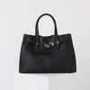 A black genuine leather women's shoulder tote bag with a top handle displayed on a white pedestal.