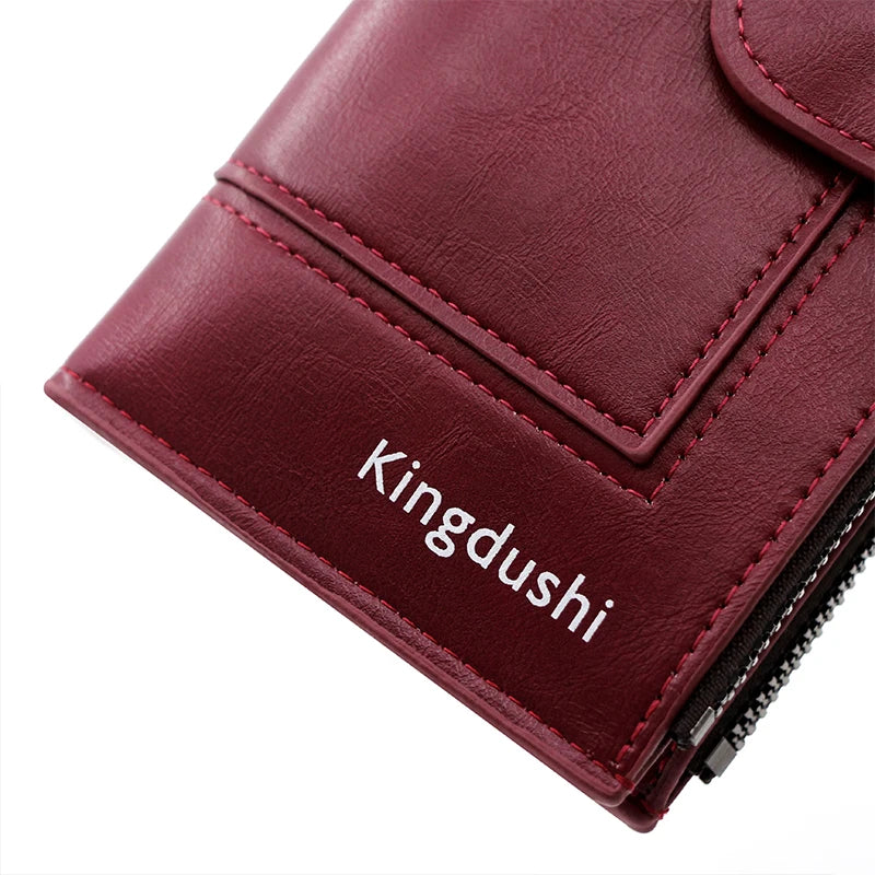 A close-up of a maroon leather wallet with the brand name Kingdushi embossed on the cover.