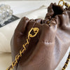 A close-up of a brown PU leather chain shoulder bag with gold hardware and a leather strap.