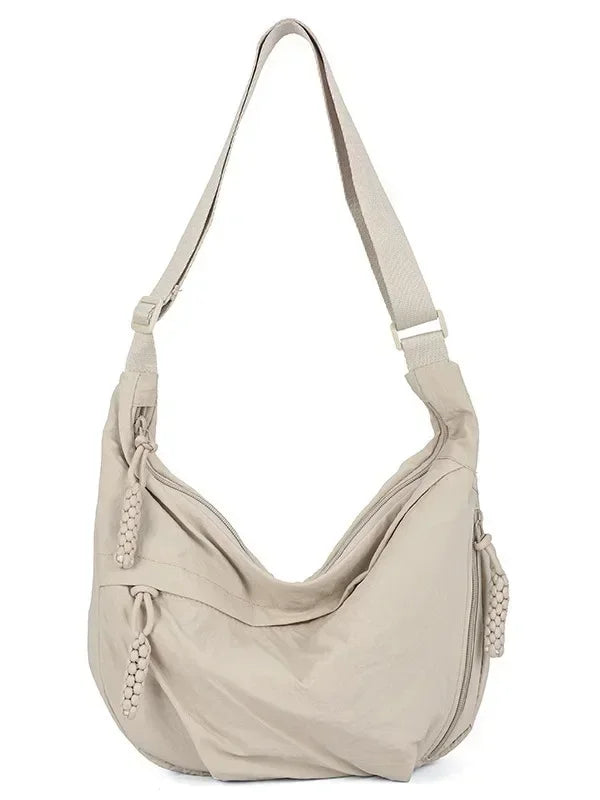 A beige soft nylon crossbody shoulder bag with an adjustable strap.