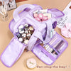 A purple multipocket travel toiletry bag filled with various cosmetic products and pink accessories.
