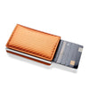A minimalist wallet with a textured orange leather cover and a black card slot.